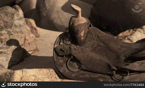 very old horse saddle on sand beach