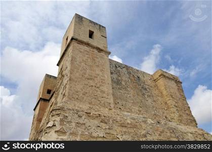 Very old tower on Malta with blue sky and clouds