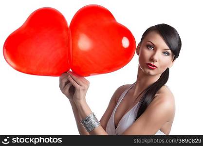 very pretty brunette takes two heart shaped baloons and looks in the camera