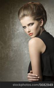 very pretty girl in fashion pose with elegant hair-style, stylish make-up and cute black dress
