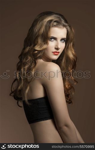 very pretty young girl with long wavy hair, cute make-up and naked shoulders