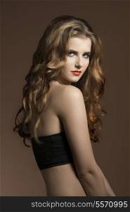 very pretty young girl with long wavy hair, cute make-up and naked shoulders