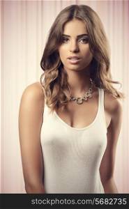 very pretty young woman wearing sexy white undershirt, stylish necklace, posing with long natural hair, looking in camera