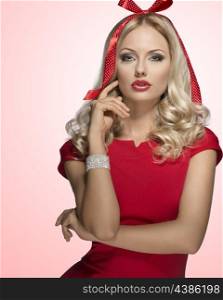 very sensual blonde female adorned like xmas present with funny bow on her head. Posing with elegant red dress and bright bracelet