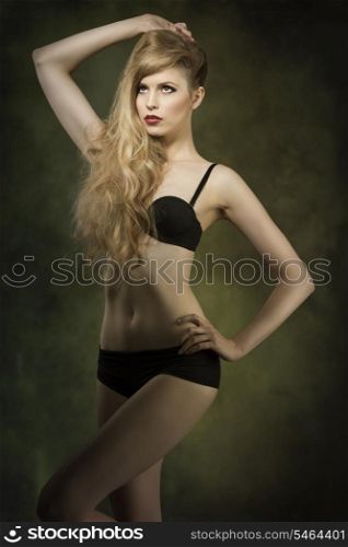 very sexy blonde woman with black lingerie and long wavy blonde hair showing her perfect body in sensual pose