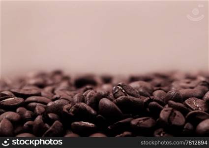 Very warm picture of coffee beans background, color corrected as old photo in beautiful sepia style. With copyspace for your text.