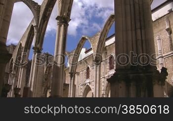 Verzierte Rundb?gen / Tore aus Stein einer alten Kathedrale; im Hintergrund das GebSude der Kathedrale; wei?e Wolken ziehen am blauen Himmel.
