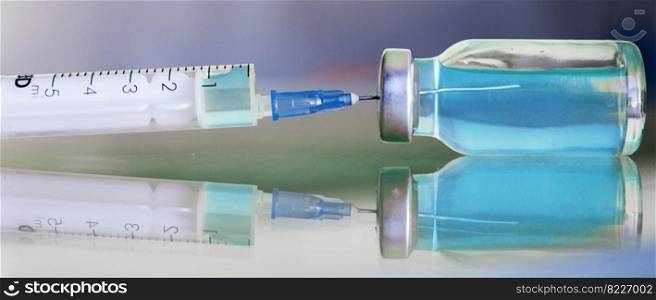 Vial filled with liquid vaccine in medical lab with syringe. medical ampoule and syringe on a glass surface. banner. Vial filled with liquid vaccine in medical lab with syringe. medical ampoule and syringe on the glass surface. banner