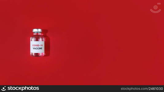 Vial with covid19 vaccine on a red background. Medical flat lay with copy space.. Vial with covid19 vaccine on red background. Medical flat lay with copy space.