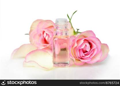 Vial with essential oil and two roses on a white background