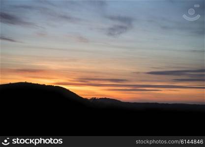 Vibrant sunset landscape over countryside hills silhouette