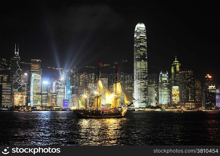 Victoria harbor with famous traditional Chinese junk at night. Hong Kong
