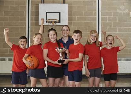 Victorious School Sports Team With Trophy In Gym