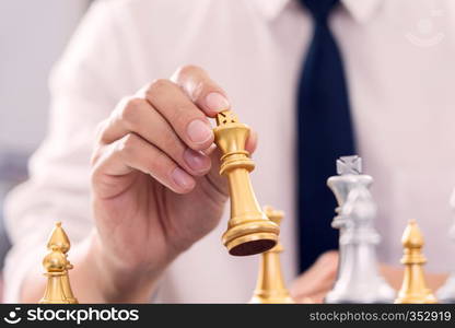 victory leader and success concept, business man playing take a checkmate figure another king with team on the chess board and thinking about strategy or management intelligence and education.