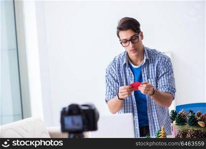 Video blogger recording making paper decoration