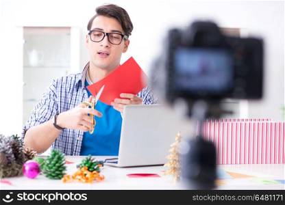 Video blogger recording making paper decoration