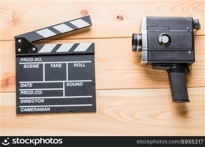 Video Clapper and Vintage Camcorder Lies on Light Wooden Boards