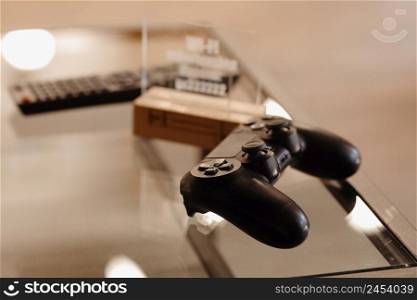 video game controller on glass table. gaming, technology and entertainment concept - blue gamepad controller on table.. video game controller on glass table. gaming, technology and entertainment concept - blue gamepad controller on table