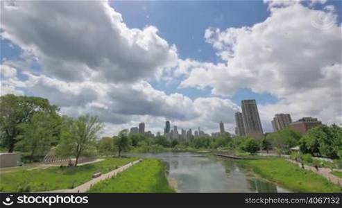 Video lapse process of clouds crossing the skyscrapers of Chicago. Panoramic view of the cityscape from Lincoln Park Zoo in Spring. Hancock Tower is one of the highest buildings in the windy city.