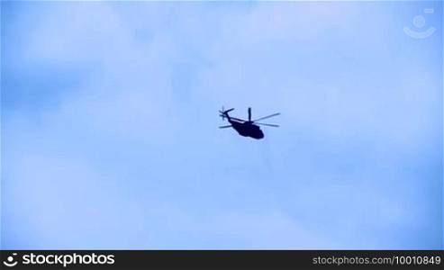 A helicopter of the Blackhawk type during an observation in the air, rotates once around its own axis