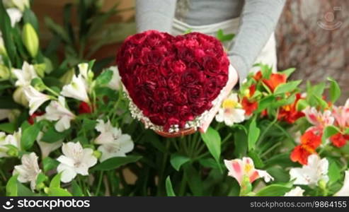 A man buying Valentine's Day rose heart bouquet in florist shop