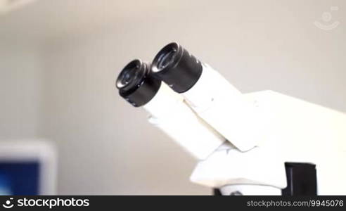 A man enters the scene and looks into the microscope
