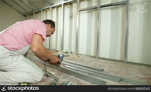 A man using a screwdriver to install drywall systems