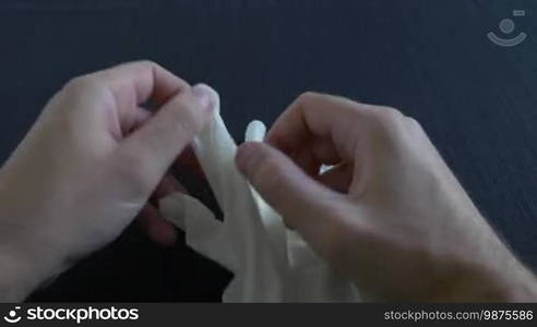 A medium shot of putting on surgical white gloves