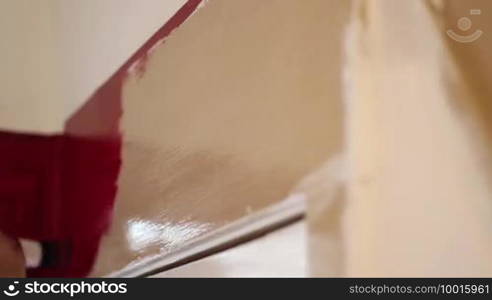 A painter is painting a door frame, time lapse of scene, very precise work and clear moves with the brush are executed