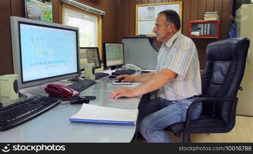 Adept engineer works on computer with three monitors