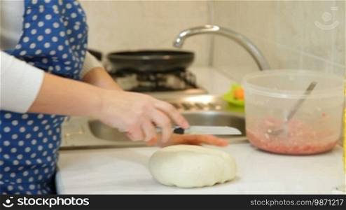 Adult woman kneading stiff dough in the kitchen, closeup