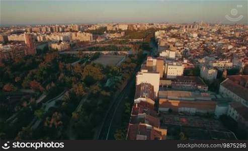Aerial morning flight above the Moscow district. View of the buildings, fountain, traffic, road, houses, and parks against the horizon, Russia