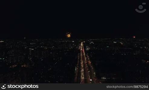 Aerial night view of the Leninsky Avenue, Moscow, Russia. Big traffic road in lights, university, buildings and sparkling fireworks in different places