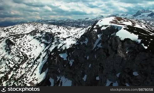 Aerial panoramic view of snowy mountains with rocks on the horizon. Many mountains for skiing. Obertraun, Austria