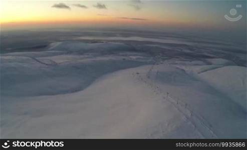 Aerial shot of sunset or sunrise over Khibiny in winter, there is a ski-lift on the mountain