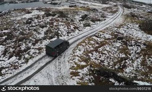 Aerial shot of the car on the country road through a wintry landscape