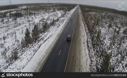 Aerial shot of the road in the countryside with car on the way