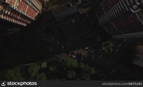 Aerial top view of typical modern sleeping district with residential buildings roofs with yard with trees and trees and playground at summer, Moscow, Russia