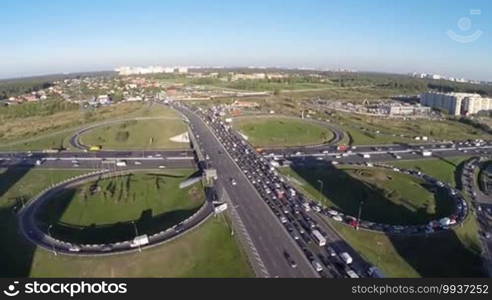 Aerial view of city traffic on highway typical cloverleaf interchange Urban transportation with traffic jams in industrial countryside area