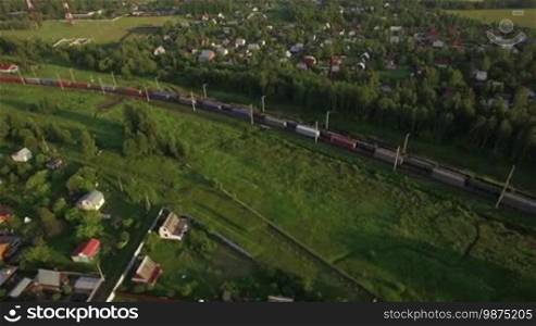 Aerial view of railway traffic running through the countryside and village, Russia