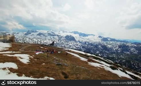 Aerial view of the take off paraglider with a green color parachute from the mountainside. Austria, Obertraun