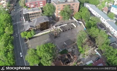 Aerial view of town with cars on the road and old ruined wooden house