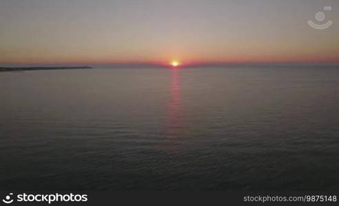 Aerial waterscape. Quiet sea with pier and distant coast at sunset. Thessaloniki, Greece