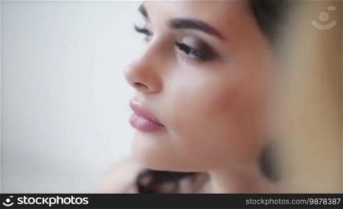 Artist applying blush to wedding makeup for bride