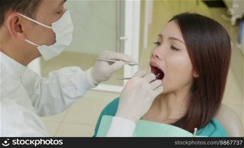 Asian doctor visiting young female patient in dentist studio, people and oral hygiene, health care and medical treatment in clinic. 15 of 19