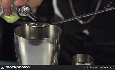 Bartender, barman is making delicious cocktail at bar counter using ice and sweet liquor, and making tricks, shots