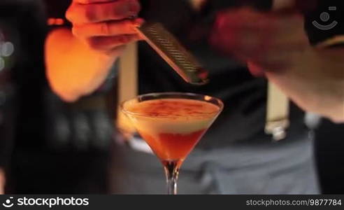 Bartender, barman is making delicious cocktail at bar counter using ice and sweet liquor, and making tricks, shots