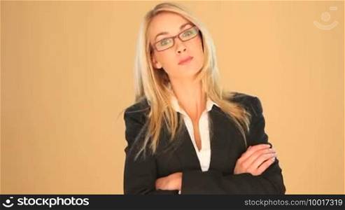 Beautiful blonde businesswoman wearing glasses with crossed arms standing smiling at the camera