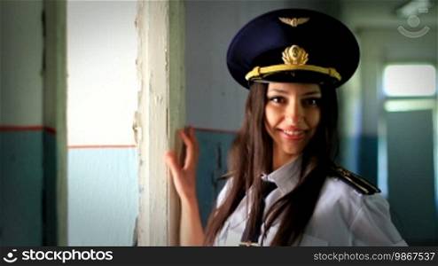 Beautiful girl posing for the camera in clothing cadet amid collapsed buildings.