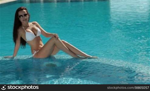 Beautiful woman relaxing in a pool on vacation